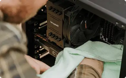 Detailfoto van iemand die voorzichtig een computeronderdeel schoonmaakt